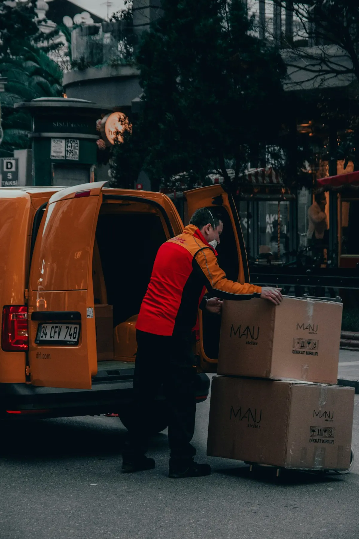 Delivery driver loading a box into a van